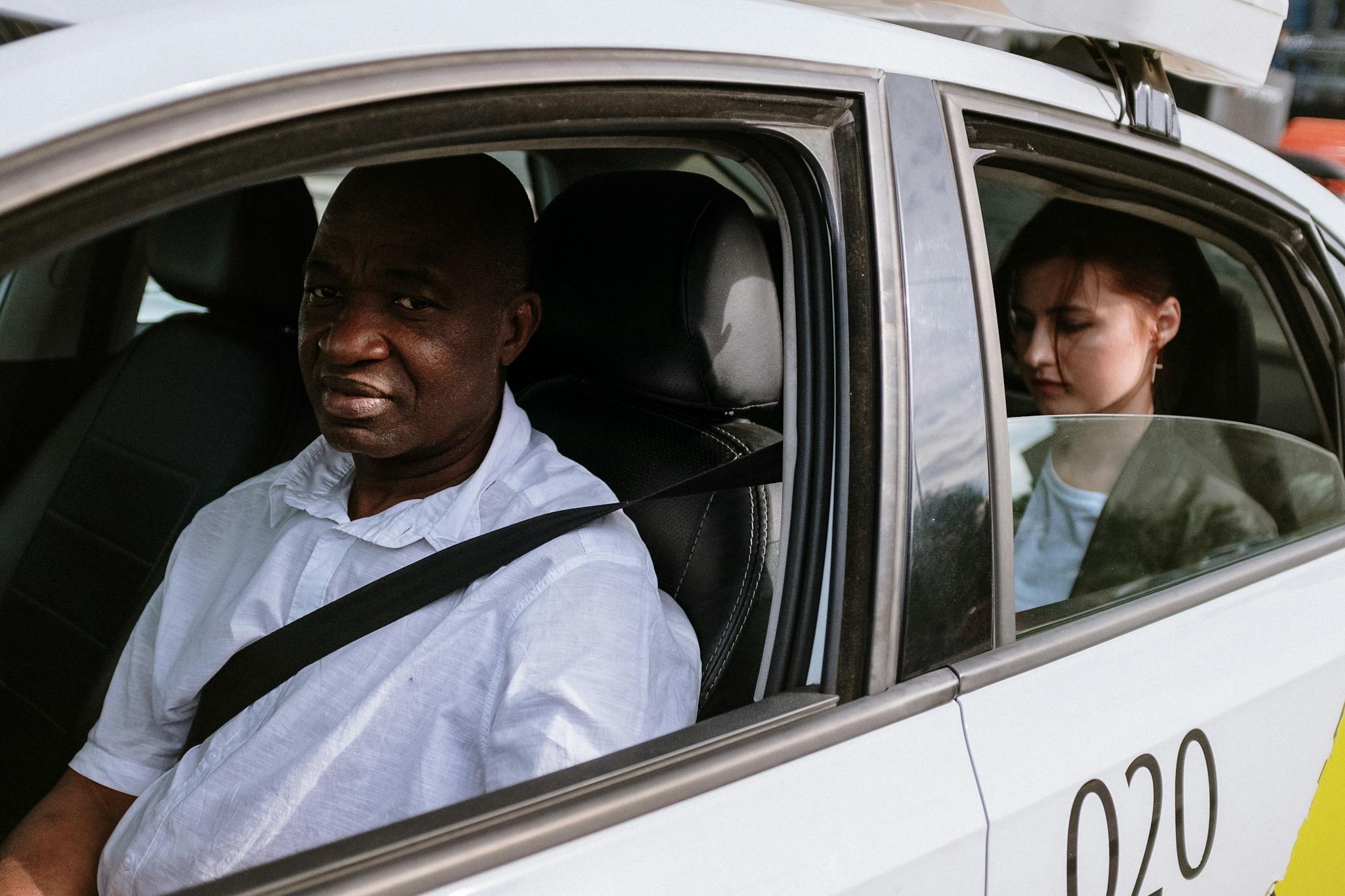 A taxi driver and passenger in a city, showcasing urban transportation.